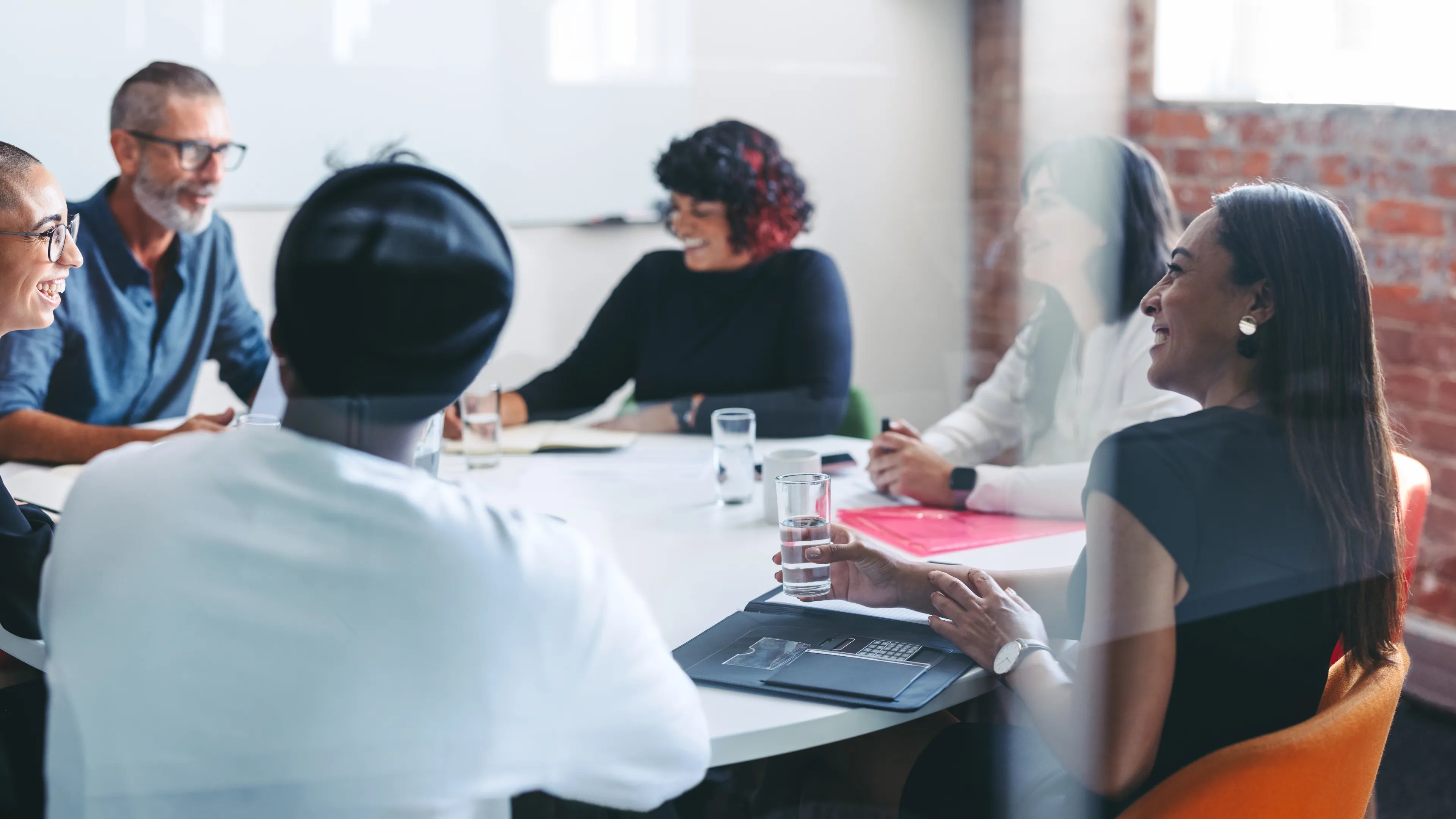 Group of people sitting together around a table speaking